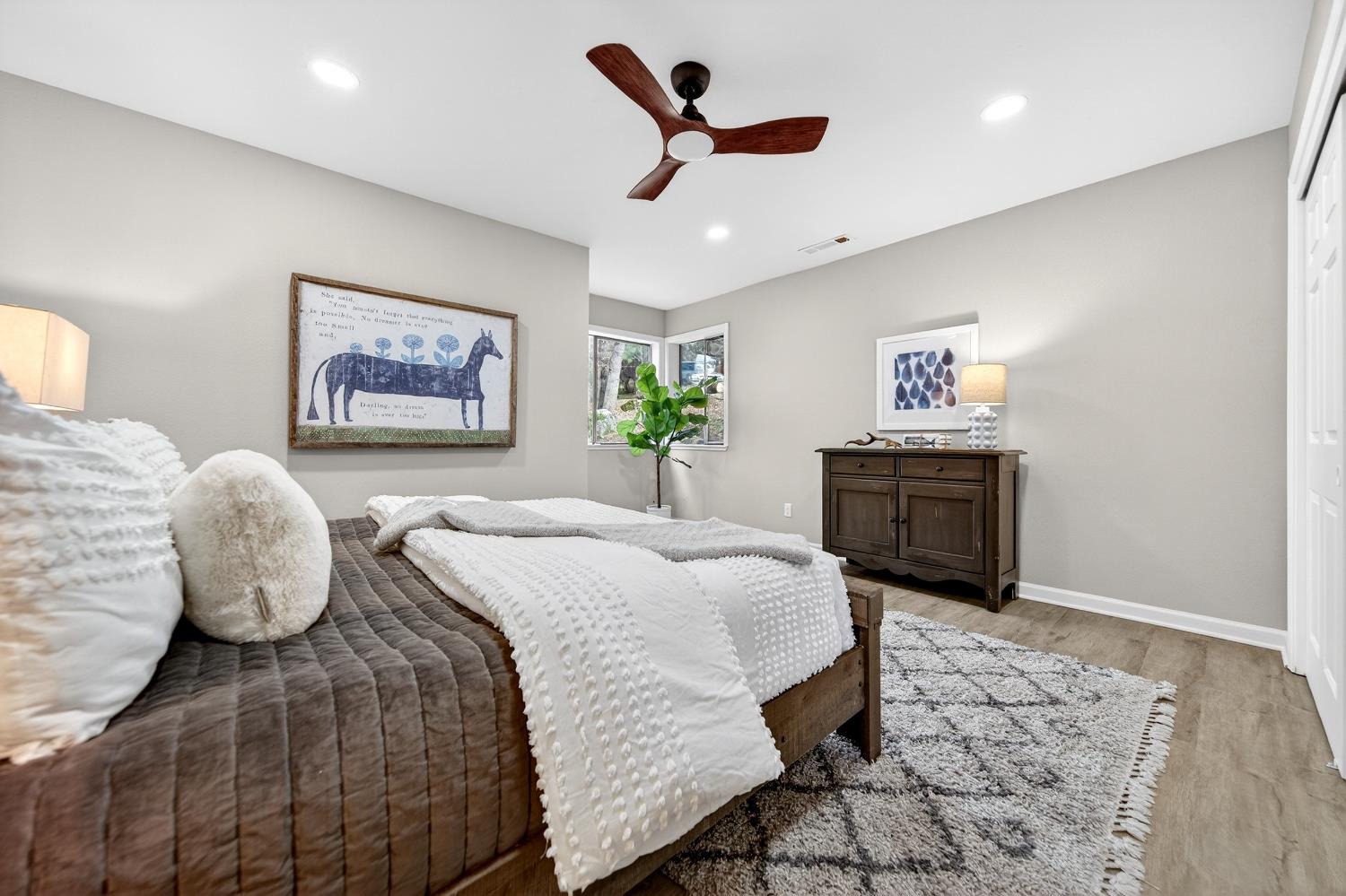 16947 Patricia Way Grass Valley, CA 95949 - Photo 24 of 50 a spacious bedroom with a bed and a chandelier