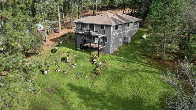 an aerial view of a house with table and chairs under an umbrella