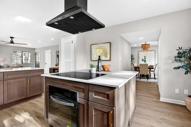 a kitchen with stainless steel appliances sink stove and wooden floor