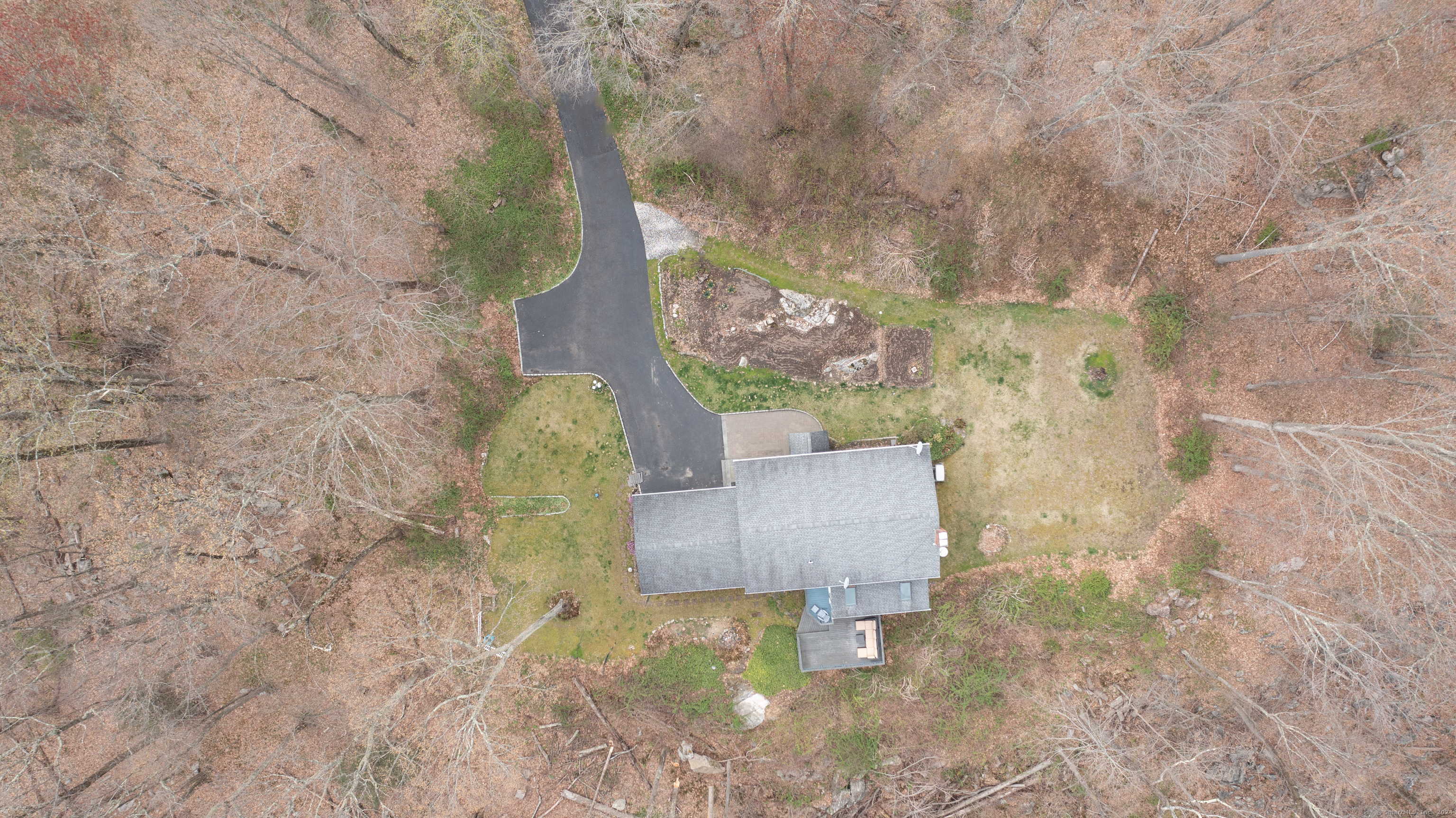 a aerial view of a house with a yard and large tree