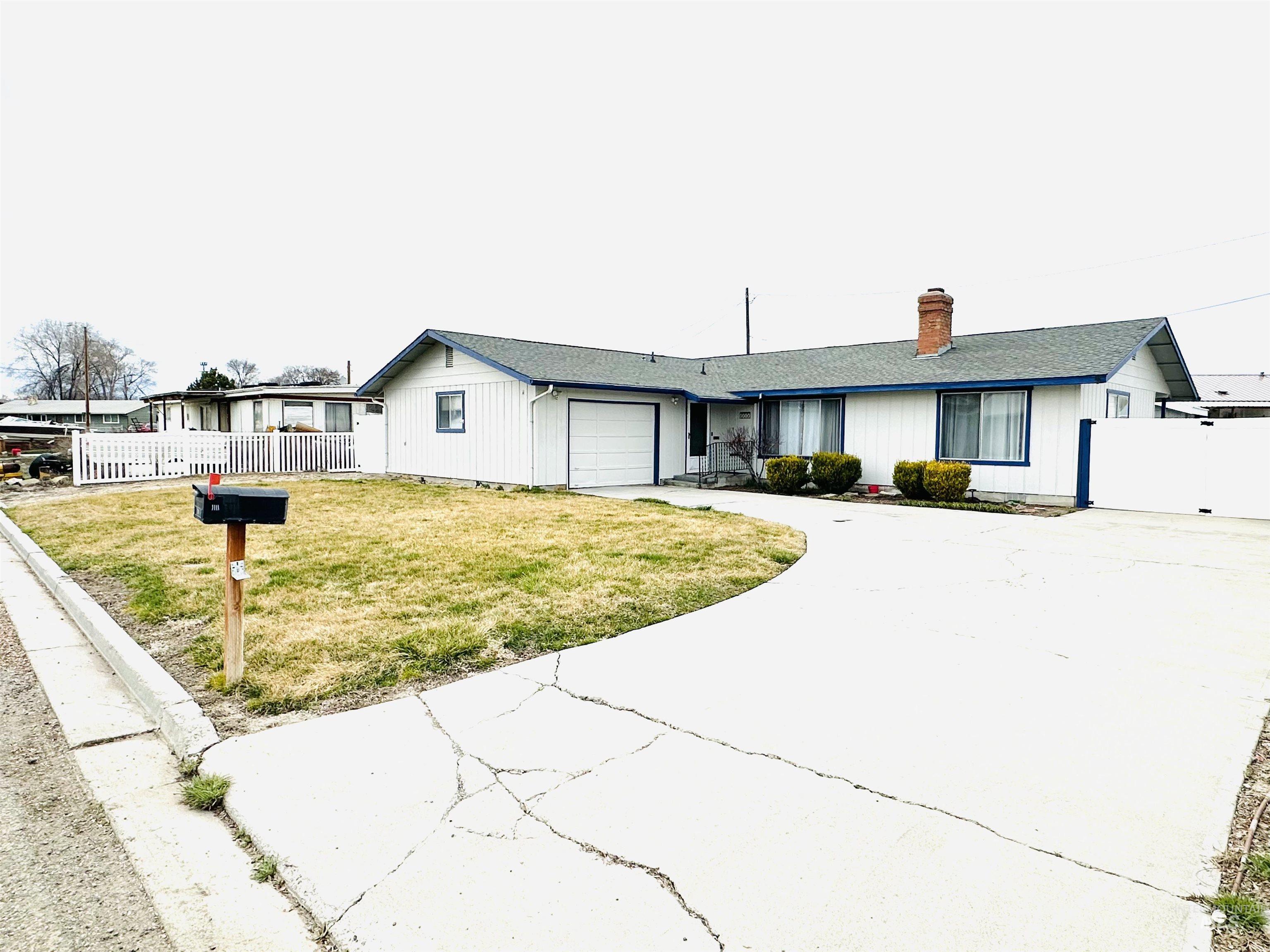 1111 West D Street Vale, OR 97918 - Photo 2 of 26 Ranch-style home with an attached garage, driveway, and a chimney