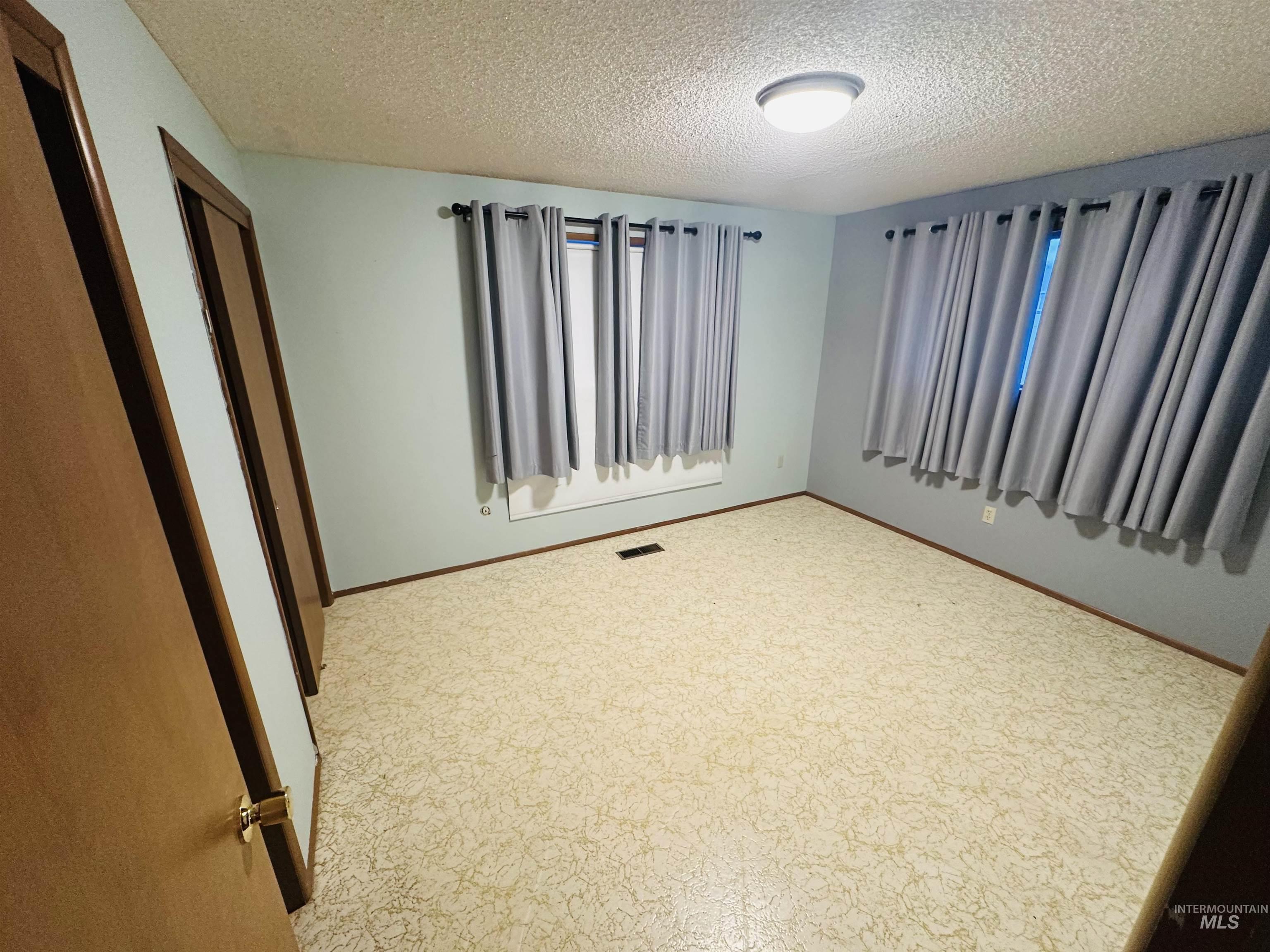 1111 West D Street Vale, OR 97918 - Photo 21 of 26 Carpeted spare room featuring a textured ceiling and baseboards