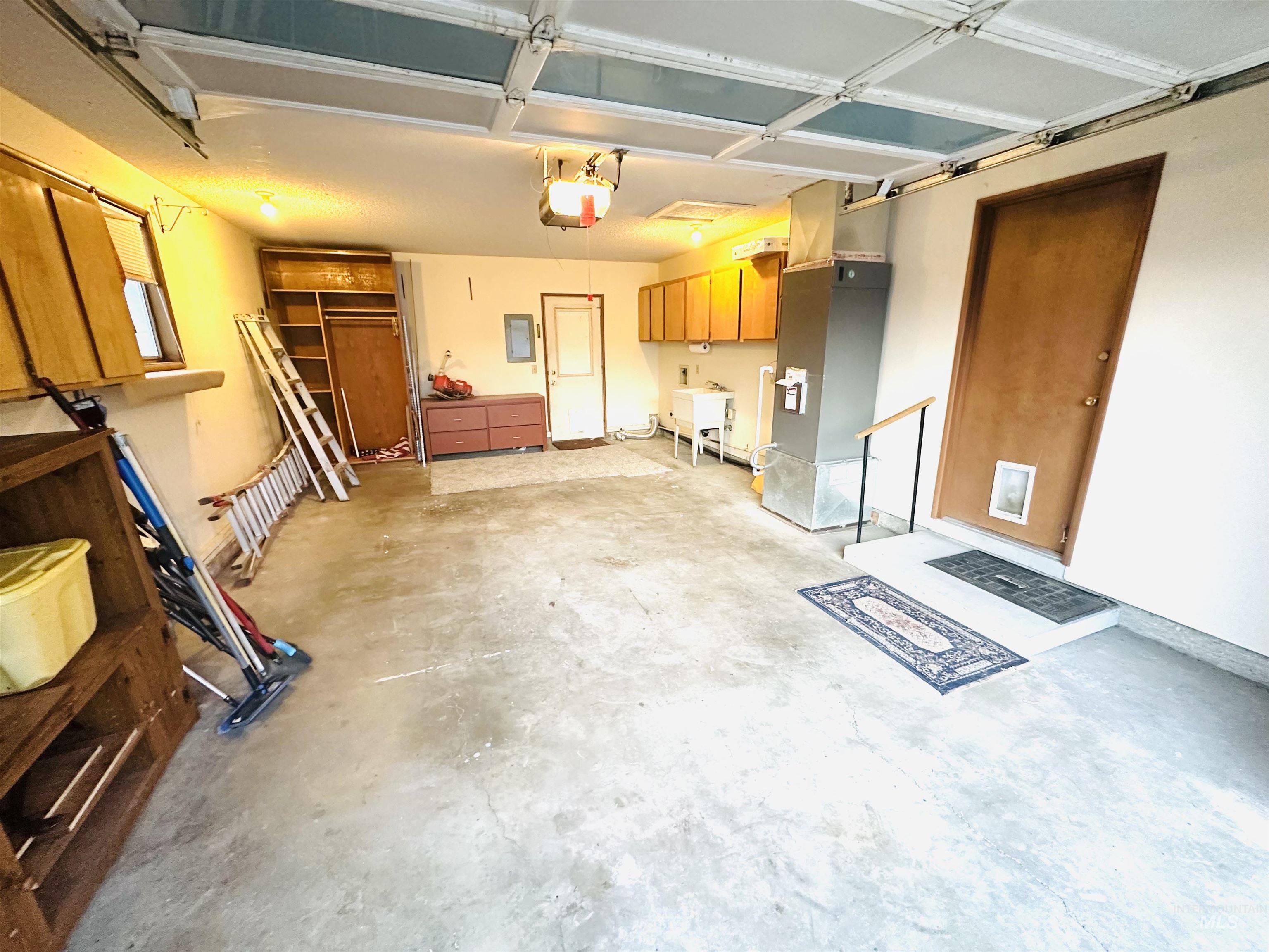 1111 West D Street Vale, OR 97918 - Photo 23 of 26 Garage featuring heating unit, electric panel, and a garage door opener