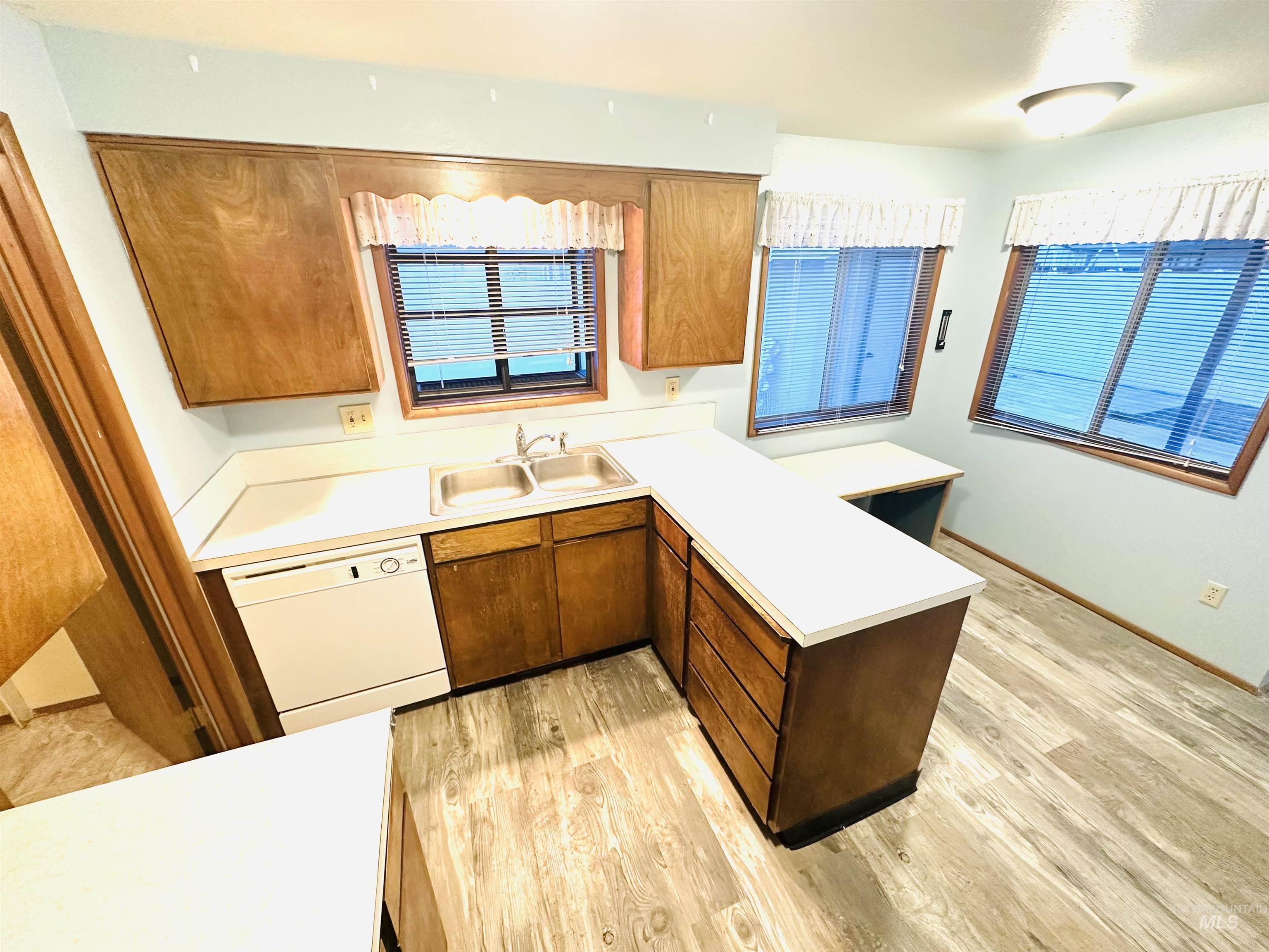 1111 West D Street Vale, OR 97918 - Photo 4 of 26 Kitchen with a peninsula, light countertops, white dishwasher, and light wood-style floors