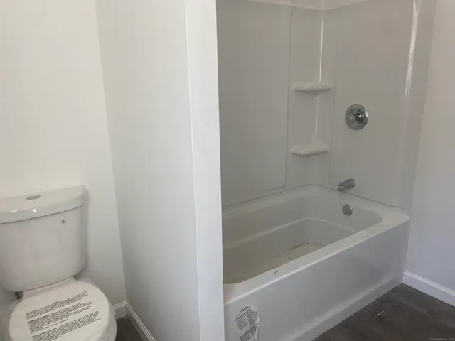 a white bath tub sitting next to a toilet
