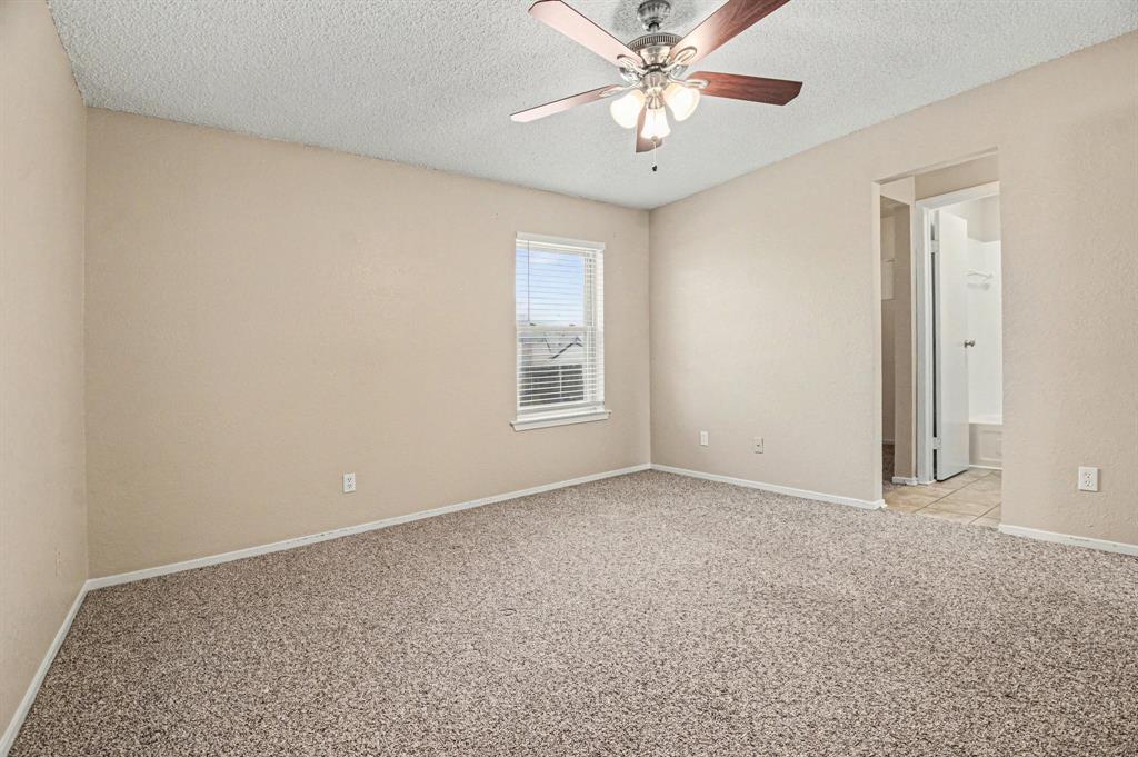 1024 South Riverside Drive Grapevine, TX 76051 - Photo 11 of 21 an empty room with a chandelier fan and windows
