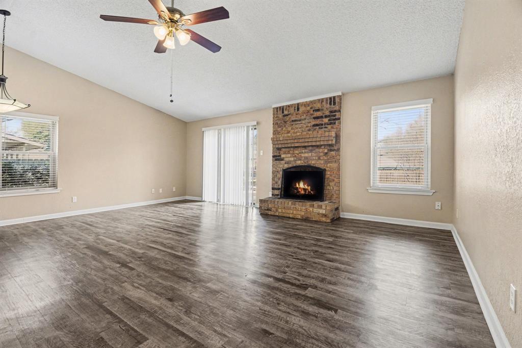1024 South Riverside Drive Grapevine, TX 76051 - Photo 3 of 21 a view of an empty room with wooden floor fireplace and a window