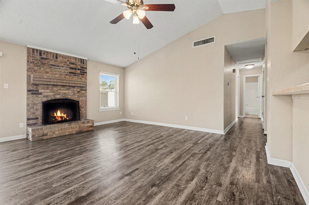1024 South Riverside Drive Grapevine, TX 76051 - Photo 5 of 21 a view of an empty room with wooden floor and fireplace