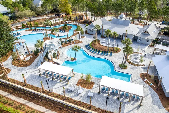 a view of swimming pool with outdoor seating and trees in the background