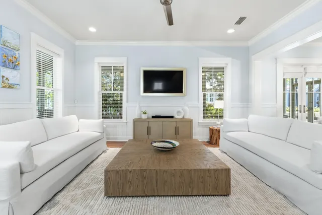 a living room with furniture a flat screen tv and a large window