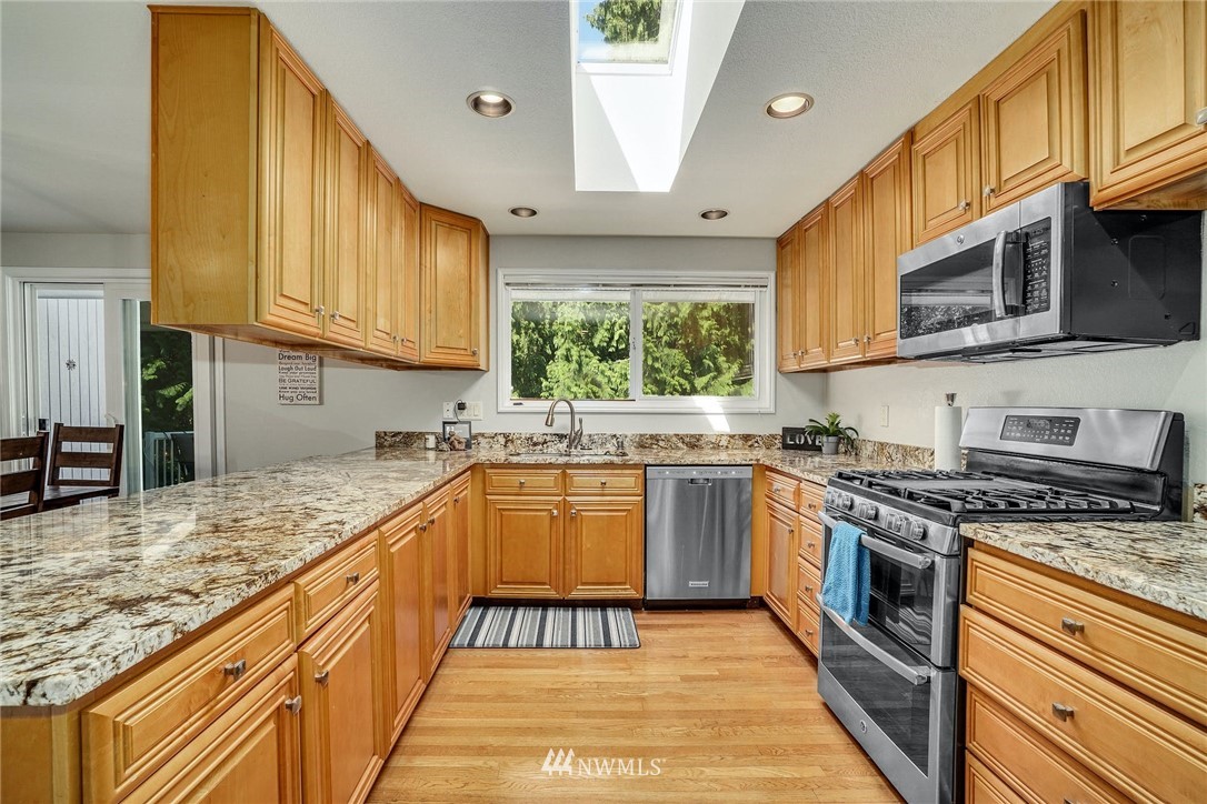 1912 169th Place Southeast Bothell, WA 98012 - Photo 11 of 40 a kitchen with stainless steel appliances granite countertop a stove a sink and a microwave