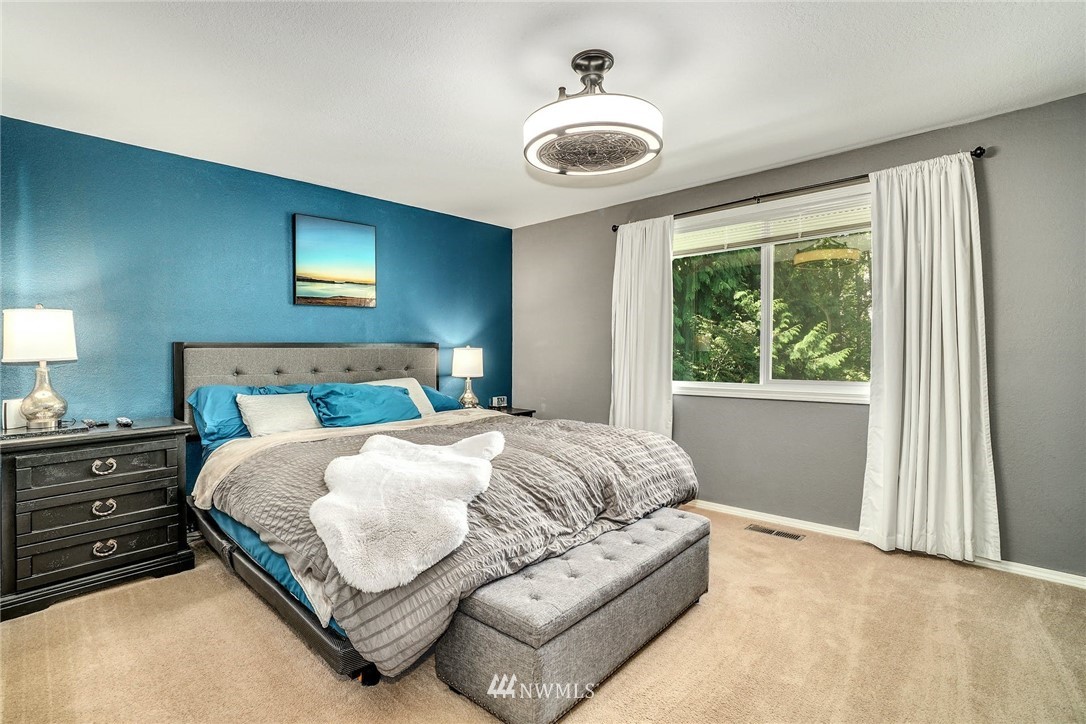 1912 169th Place Southeast Bothell, WA 98012 - Photo 13 of 40 a bedroom with a large bed and a chandelier