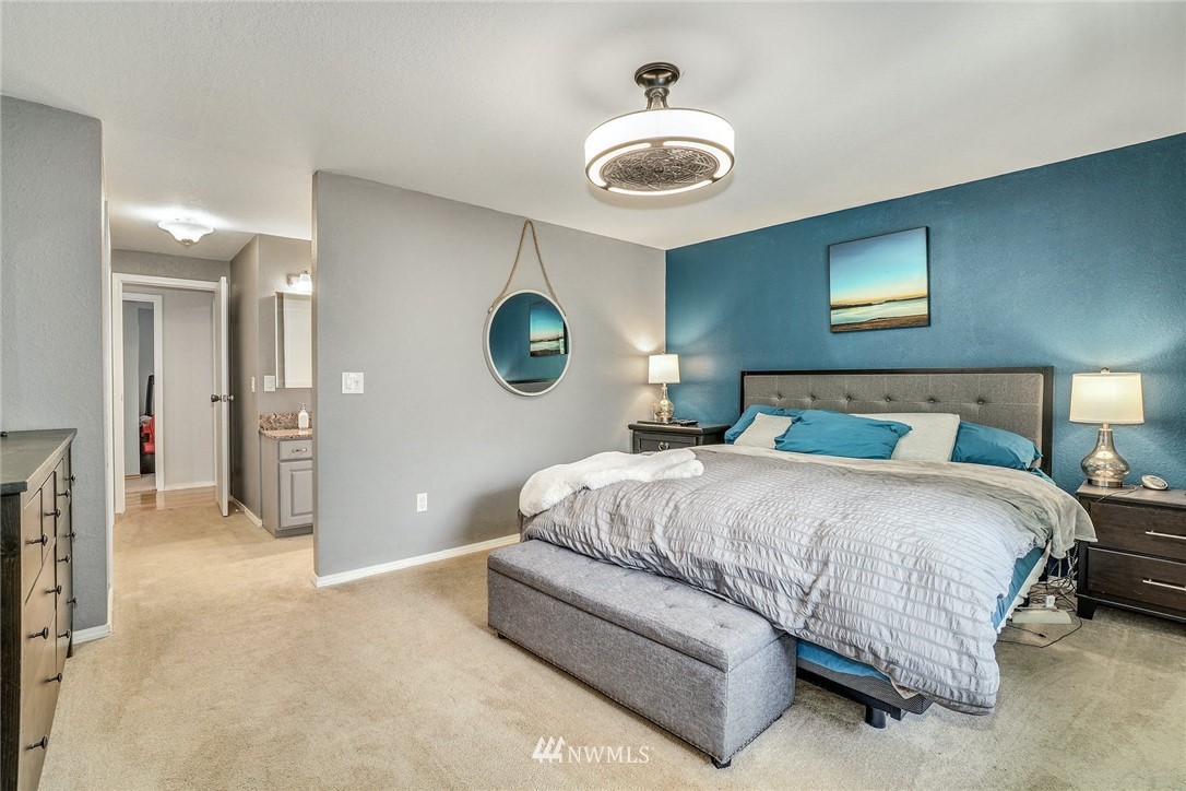 1912 169th Place Southeast Bothell, WA 98012 - Photo 14 of 40 a spacious bedroom with a bed and a chandelier
