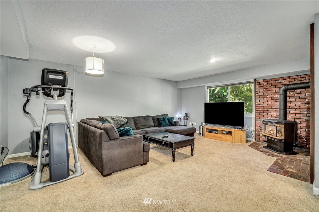 1912 169th Place Southeast Bothell, WA 98012 - Photo 21 of 40 a living room with furniture a flat screen tv and a fireplace