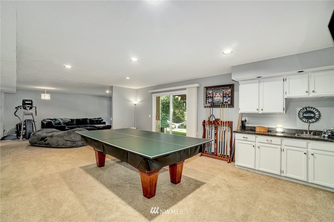 1912 169th Place Southeast Bothell, WA 98012 - Photo 22 of 40 a kitchen with stainless steel appliances granite countertop a stove a sink a refrigerator and white cabinets with wooden floor