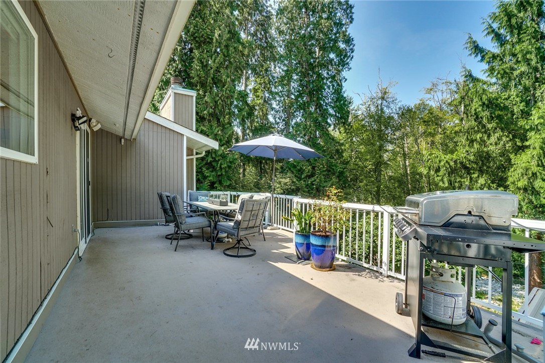 1912 169th Place Southeast Bothell, WA 98012 - Photo 28 of 40 a roof deck with table and chairs under an umbrella with a small yard