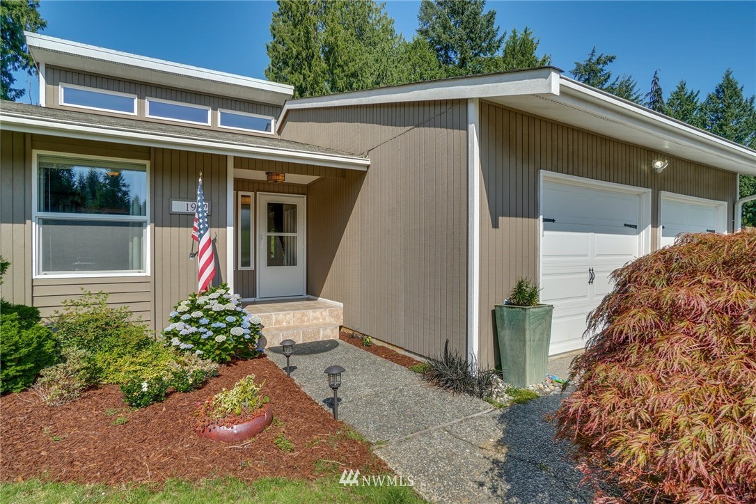 1912 169th Place Southeast Bothell, WA 98012 - Photo 4 of 40 a view of a house with small yard plants and a large tree