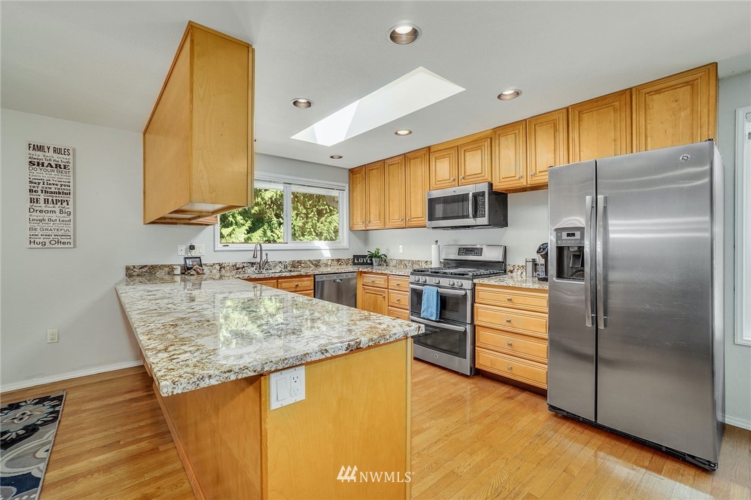 1912 169th Place Southeast Bothell, WA 98012 - Photo 10 of 40 a kitchen with stainless steel appliances granite countertop a sink a stove and a refrigerator