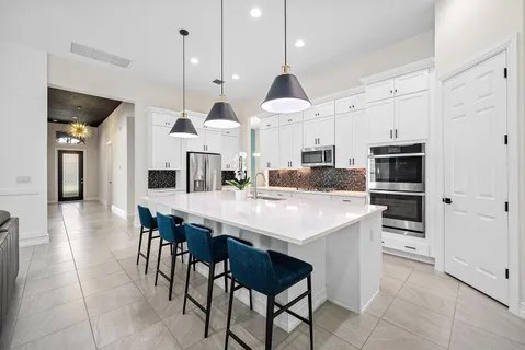 a large kitchen with stainless steel appliances kitchen island granite countertop a stove and a view of living room