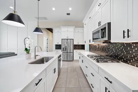 a kitchen with stainless steel appliances kitchen island granite countertop a kitchen island and chairs in it
