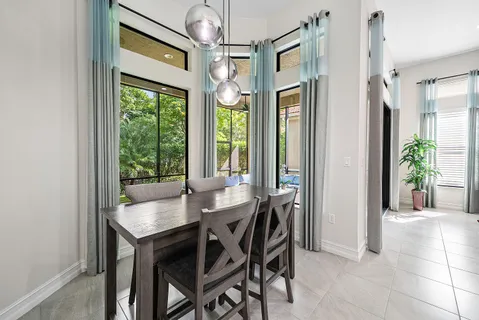 a living room with furniture a chandelier and kitchen view