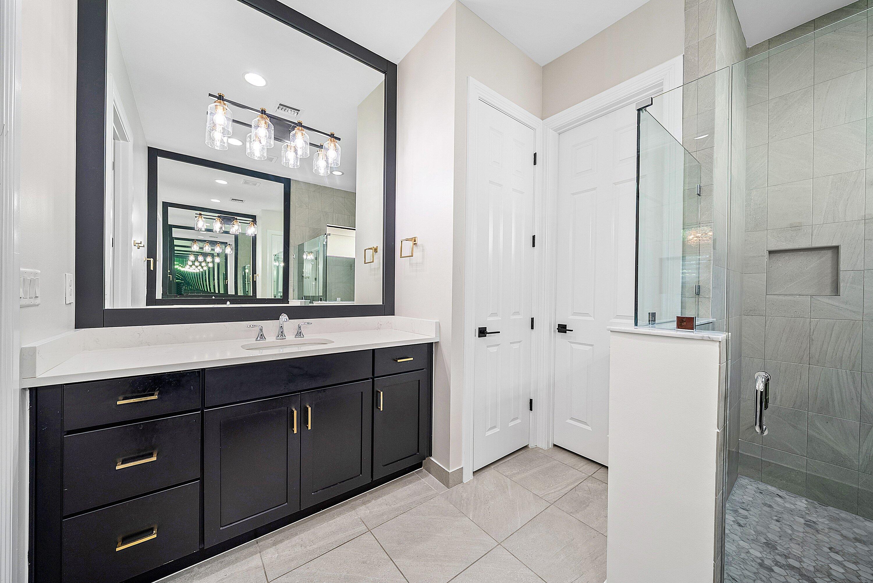 9076 Leon Circle Parkland, FL 33076 - Photo 28 of 42 a spacious bathroom with a double vanity sink a mirror and a shower