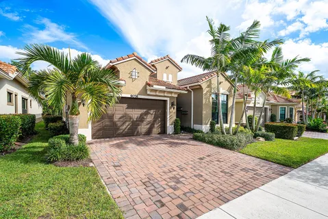 a front view of a house with a tree in a yard