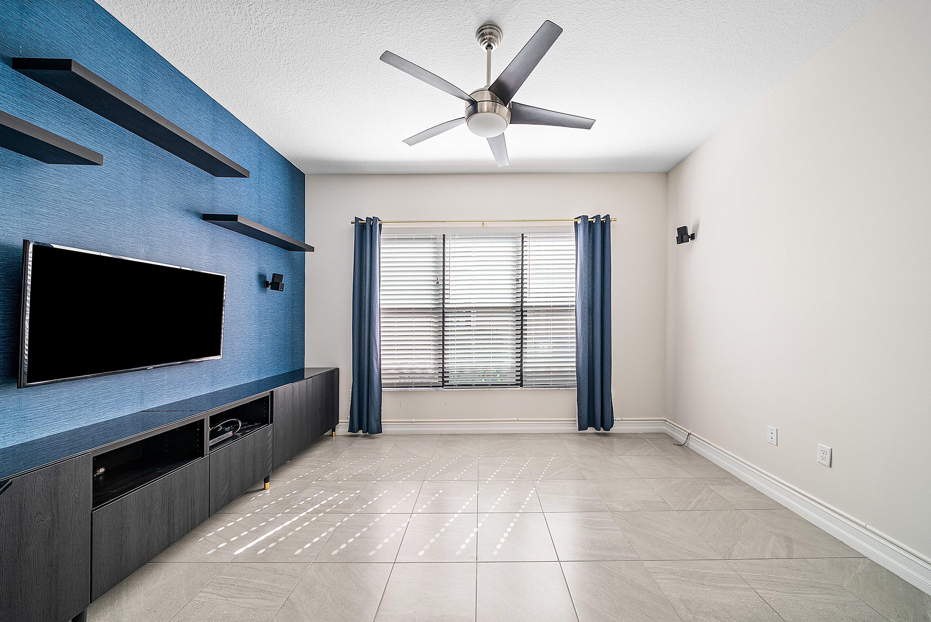 9076 Leon Circle Parkland, FL 33076 - Photo 8 of 42 a living room with a flat screen tv and a ceiling fan