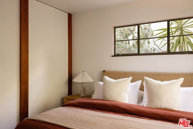 a room with stainless steel appliances lots of furniture and a large window