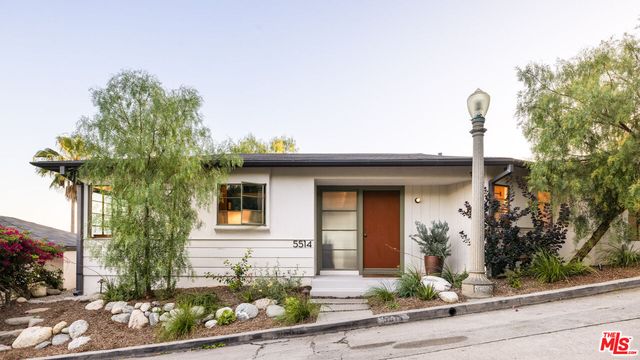 a front view of a house with a yard garage and outdoor seating
