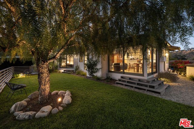 a backyard of a house with wooden floor and outdoor seating