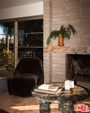 a living room with furniture large windows and a fireplace