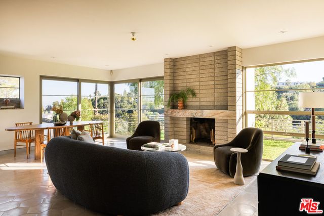 a living room with fireplace furniture and a large window