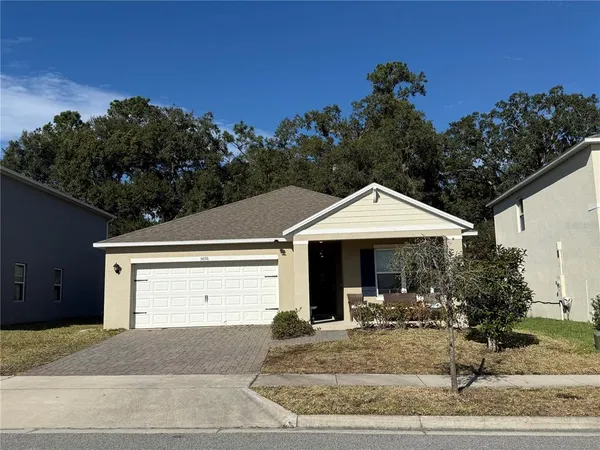 a view of a house with backyard and trees