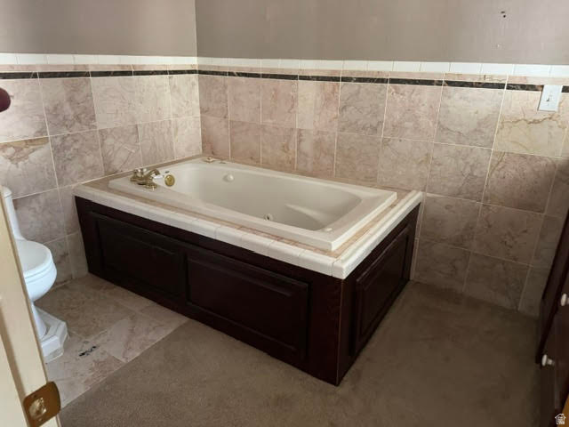 1124 Washam Road Green River, WY 82938 - Photo 25 of 35 Built-in soaking tub with decorative brass fixtures, set within a wood-panel surround