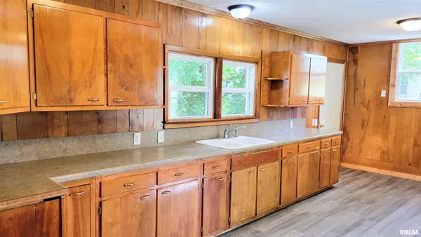 a kitchen with stainless steel appliances wooden cabinets a sink and a large window