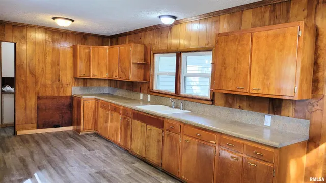 a kitchen with stainless steel appliances wooden cabinets a sink and a large window