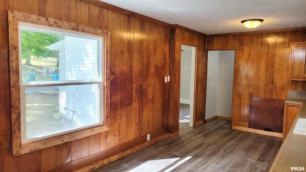 an empty room with wooden floor and windows with curtains view