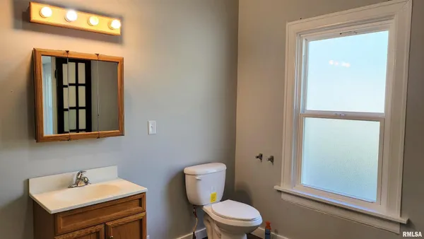 a bathroom with a toilet a sink and mirror
