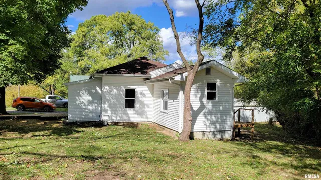 a front view of a house with a yard and trees