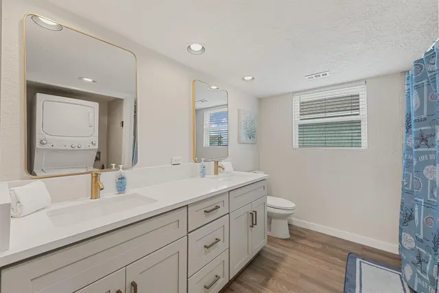 a bathroom with a double vanity sink toilet and mirror