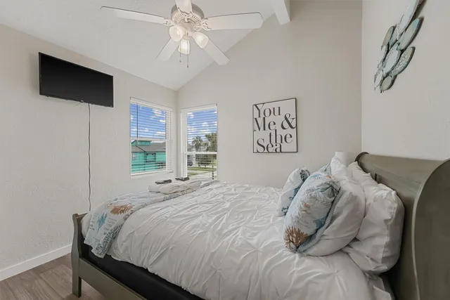 a bedroom with a large bed and a flat tv screen