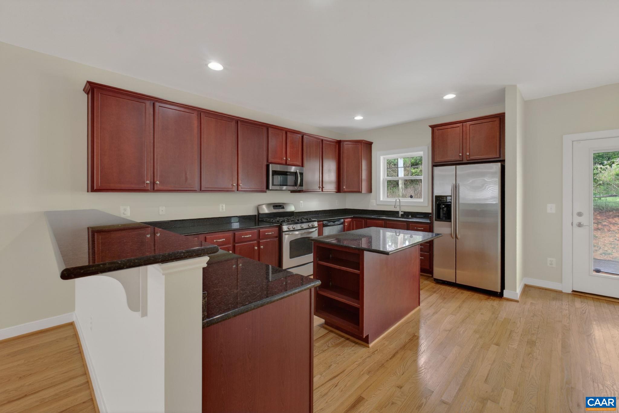 2138 Sundown Place Charlottesville, VA 22911 - Photo 15 of 38 a kitchen with stainless steel appliances granite countertop a refrigerator stove and a sink with wooden floors