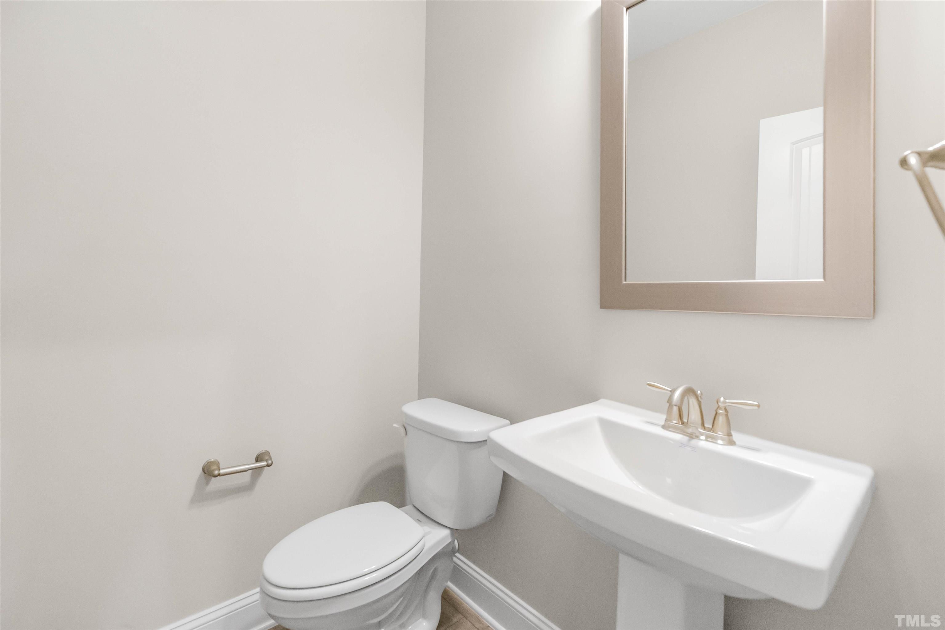 188 Painters Mill Wendell, NC 27591 - Photo 12 of 27 a white toilet sitting next to a bathroom sink