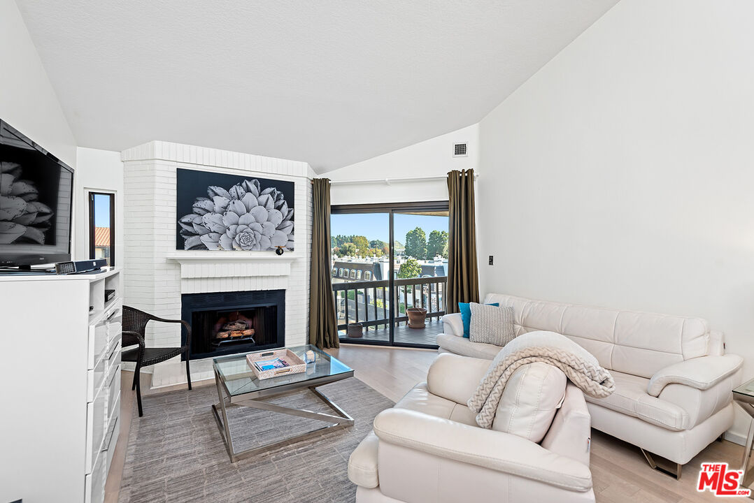8600 Tuscany Avenue, Unit 419 Playa del Rey, CA 90293 - Photo 8 of 35 a living room with furniture a flat screen tv and a fireplace