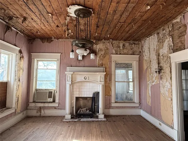 a view of a livingroom with wooden floor and a fireplace