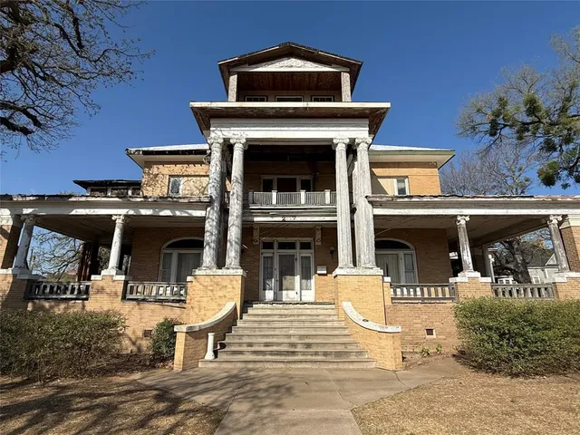 a view of a patio with table and chairs potted plants and a fireplace