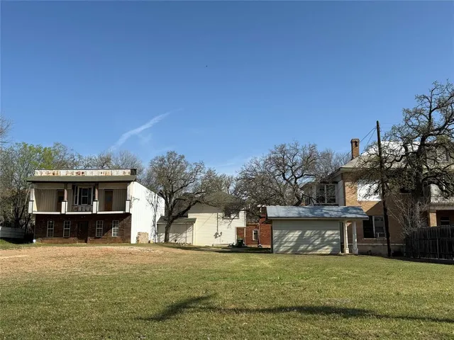 a front view of house with yard and trees in the background