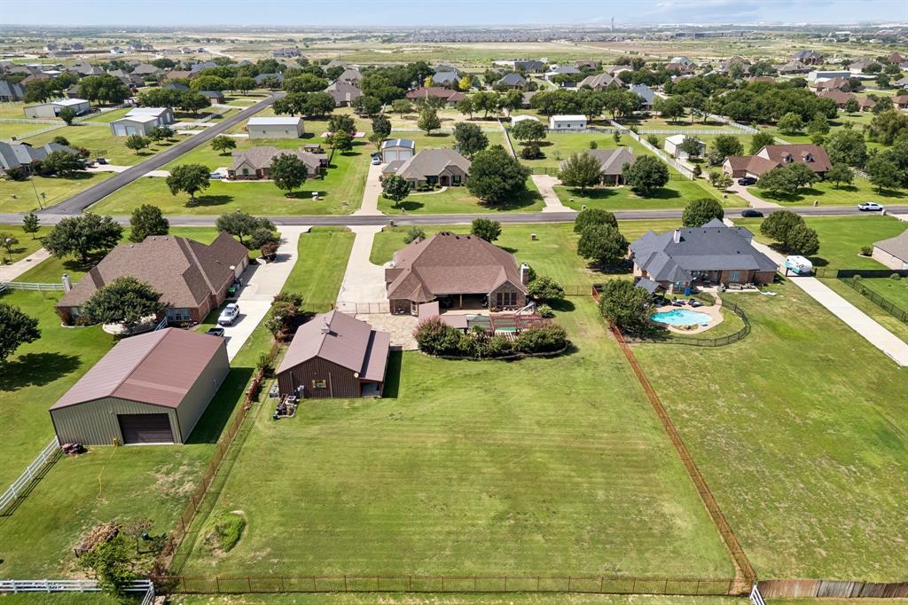 317 Singing Quail Trail Haslet, TX 76052 - Photo 32 of 32 Expansive property featuring a large main residence, a detached auxiliary building with a brown metal roof, and a separate metal-sided outbuilding with a garage door