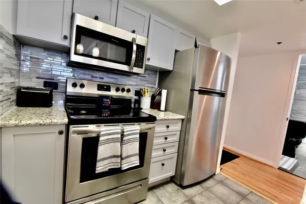 a kitchen with stainless steel appliances a stove microwave and refrigerator